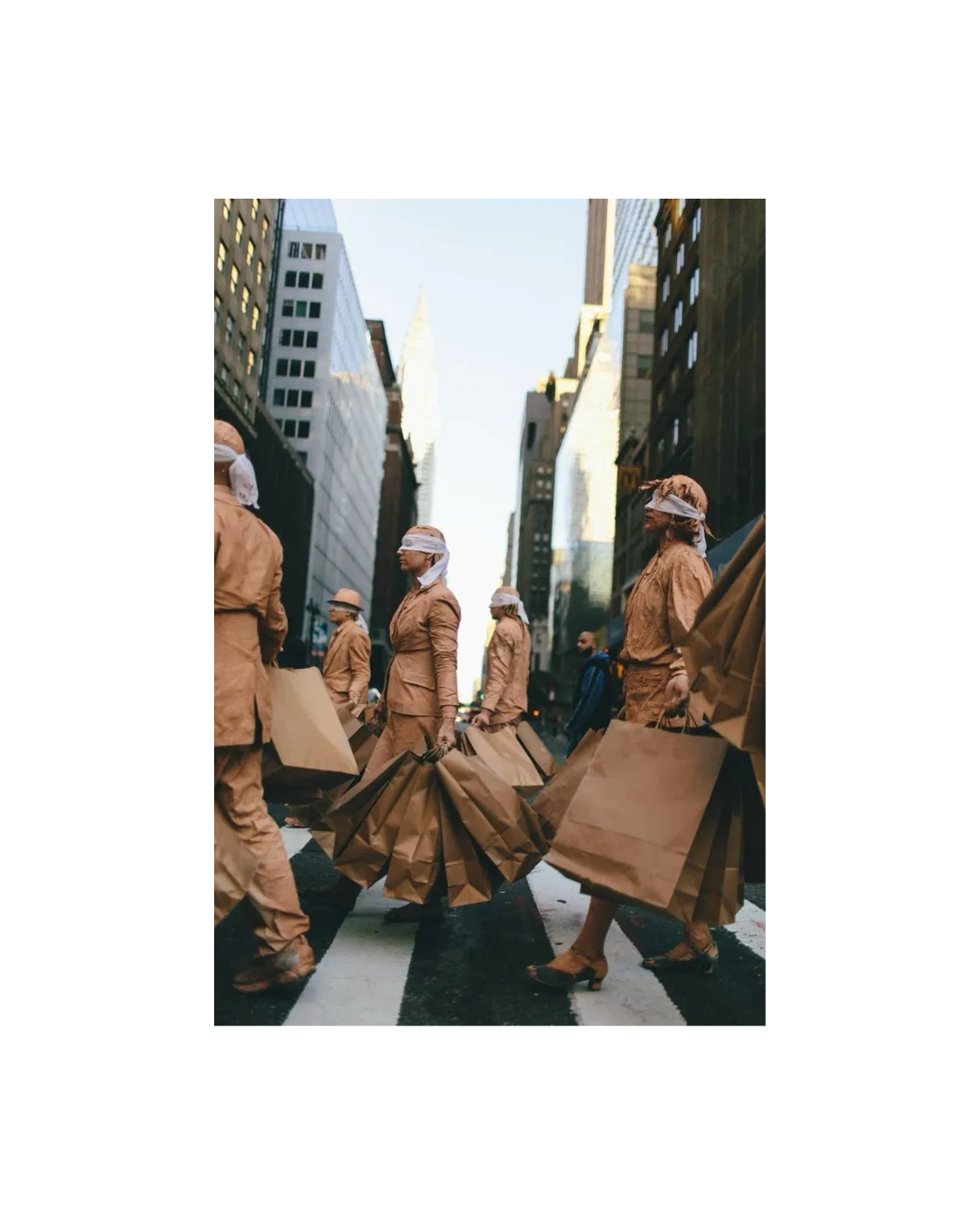 People in matching tan outfits crossing a NYC street